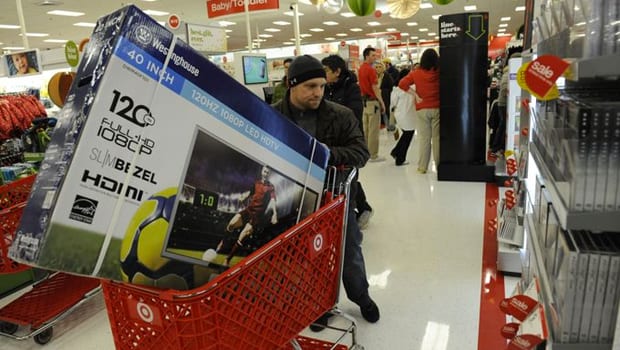 Man standing next to Target shopping cart waiting for the store to open