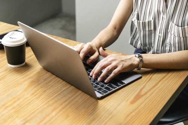 women typing at a laptop