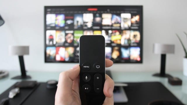 Hand holding a remote for a 4k TV