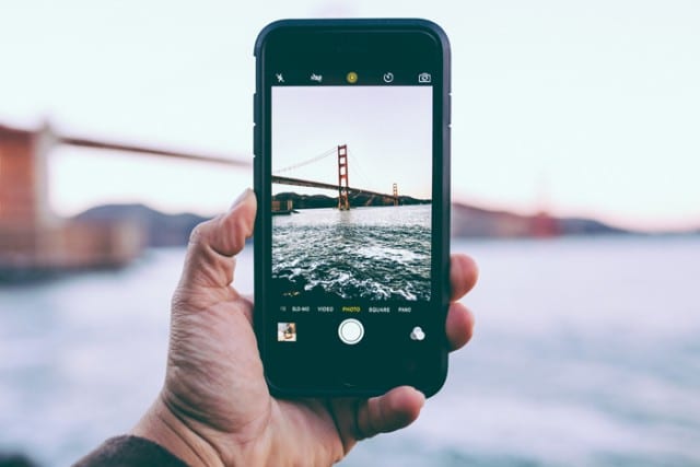 man taking a photo on a refurbished iPhone