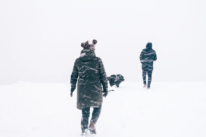 couple walking in the snow looking warm in their Canada Goose jackets