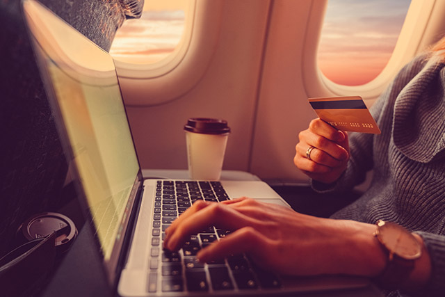 Passenger shopping online with credit card in the airplane