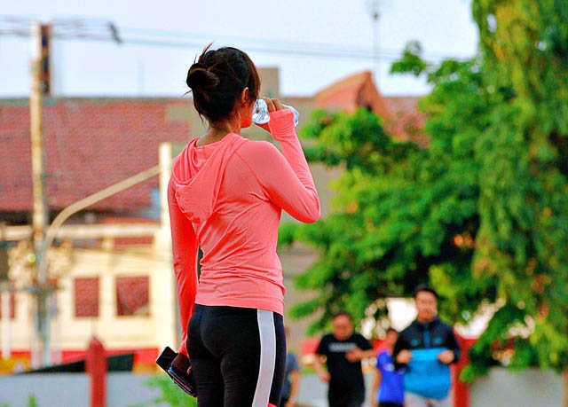 woman in leggings drinking water