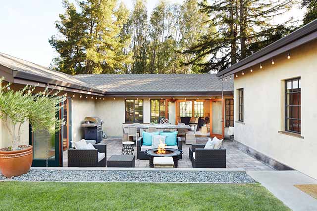 rattan patio furniture in a backyard with a fire pit